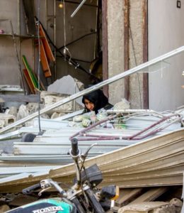 A woman sitting in the middle of what’s left from her house cleaning it and searching for her lost documents. Al Mishlab, east of Raqqa city © Diala Ghassan/MSF