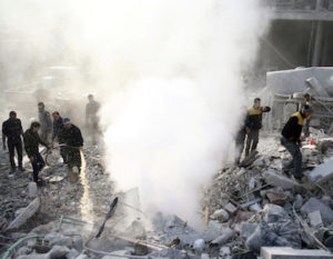 People stand on rubble of damaged buildings after an airstrike in the besieged town of Hamoria, Eastern Ghouta, in Damascus, Syria Janauary 9, 2018. REUTERS/Bassam Khabieh - RC1A03C21970