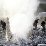 People stand on rubble of damaged buildings after an airstrike in the besieged town of Hamoria, Eastern Ghouta, in Damascus, Syria Janauary 9, 2018. REUTERS/Bassam Khabieh - RC1A03C21970