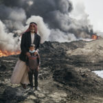 Nadak Aziz and Kharim Ali, a village elder an a young boy pose for a portrait near the Qayyarah oil fires. October 25th, 2016. Joey L./Oxfam