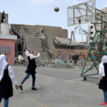 Palestinian students play basketball inside their damaged school nearby a building that was destroyed by Israeli air strikes, in Gaza City May 7, 2019. REUTERS/Mohammed Salem