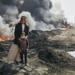 Nadak Aziz and Kharim Ali, a village elder an a young boy pose for a portrait near the Qayyarah oil fires. October 25th, 2016. Joey L./Oxfam